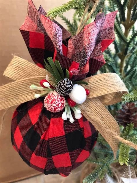 A Christmas Ornament Hanging From A Tree With Pine Cones And Berries On It