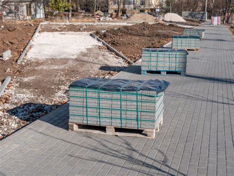 A Gray Paving Stone On Wooden Pallets Stands Outside During A Street