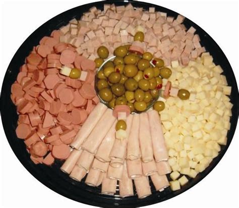 An Assortment Of Meats And Vegetables On A Platter With Olives Pickles