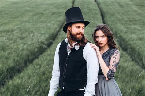 Novios Elegantes Caminando Y Posando En Campo Verde Foto Premium