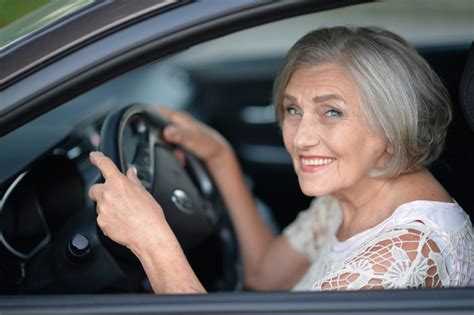 An Older Lady Driving A Car