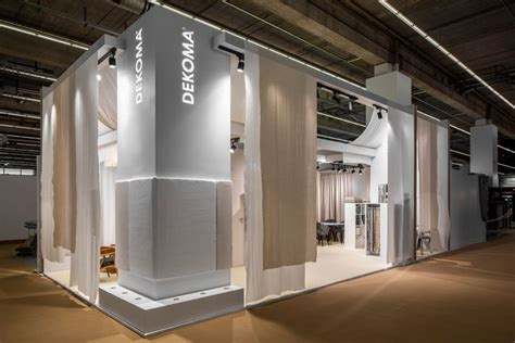 An Exhibition Booth With White Walls And Curtains