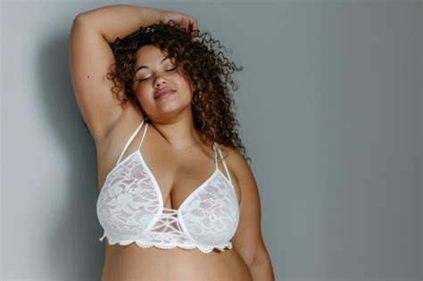 Confident Plussize Model Posing In White Lingerie On A Gray Background