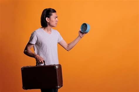 Premium Photo Young Asian Traveler Running Late Holding Retro Alarm