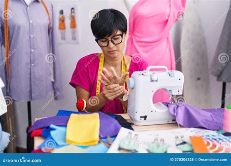 Middle Age Chinese Woman Tailor Stressed Using Sewing Machine At