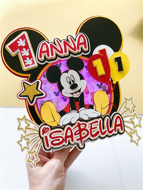 a person holding up a mickey mouse sticker
