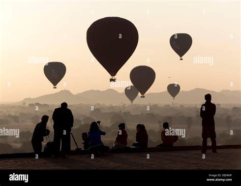 Tourists Photographing Hot Air Balloons Over The Temples Of Bagan Pyathada Paya Burma