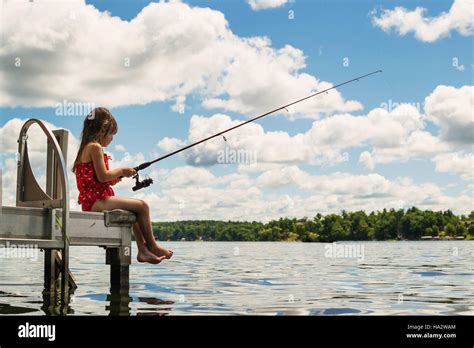 Girl Sitting On Dock Fishing Stock Photo Alamy