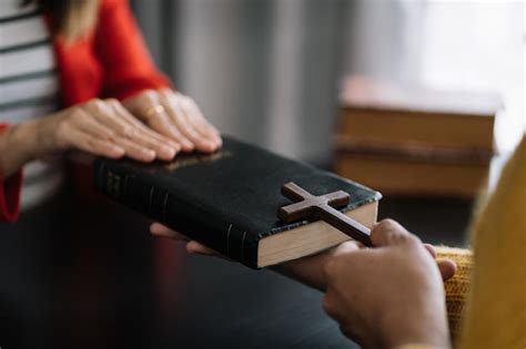 Hombres y mujeres asiáticos manos orando a dios con la biblia orar por