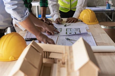 Engineer Pointing At Blueprint And Using Laptop To Draw Project Design