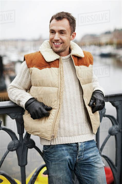 Happy Man Leaning On Railing Outdoors Stock Photo Dissolve