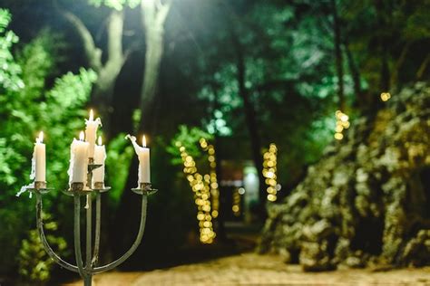 Velas encendidas para iluminar un jardín durante una cena en la noche