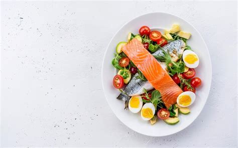 Premium Photo Ketogenic Diet Breakfast Salt Salmon And Baked Dorado Salad With Greens Tomatoes