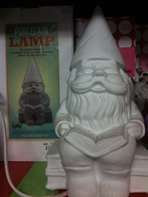 A White Gnome Statue Sitting On Top Of A Table