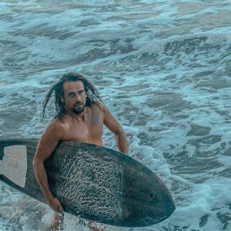 Frau im schwarzen Bikini hält Surfbrett auf Meereswellen Schiebepuzzle auf Sliding Tiles Puzzle