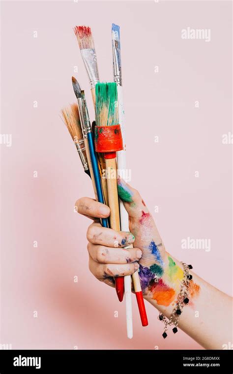 Creative background. Female artist hand holding colorful paintbrushes ...