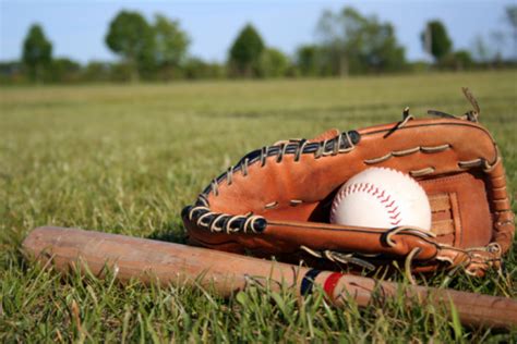 Baseball Bat Mitt And Glove Lying In Grass On A Field Stock Photo