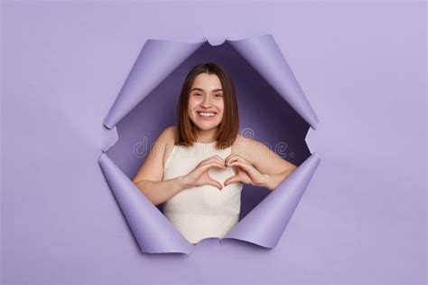 Smiling Cheerful Brunette Woman Breaking Through Purple Paper Hole