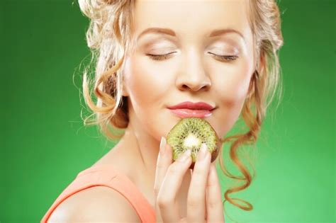 Premium Photo Young Smiling Woman Holding Kiwi