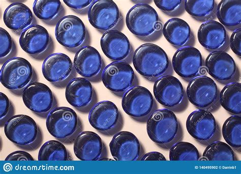 Photo Of Blue Glass Pebbles Arranged On White Background Stock Photo