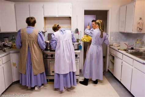 Three Women In Long Purple Dresses Are Standing At The Kitchen Sink And