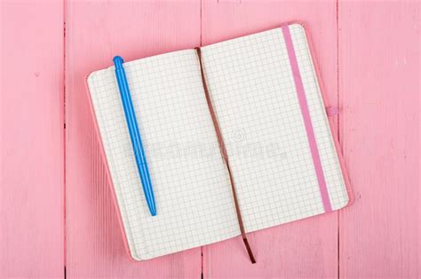 Cuaderno De Notas Y Pluma En Blanco En La Madera Rosada Foto De Archivo