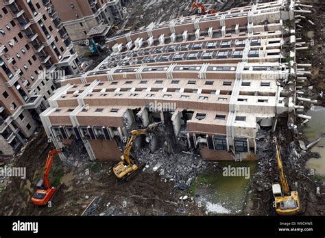 Excavators Are Seen Dismantling The Toppled Apartment Building At The