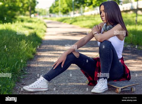 Sporty Girl Sitting On Skateboard On Street Outdoors Urban Lifestyle