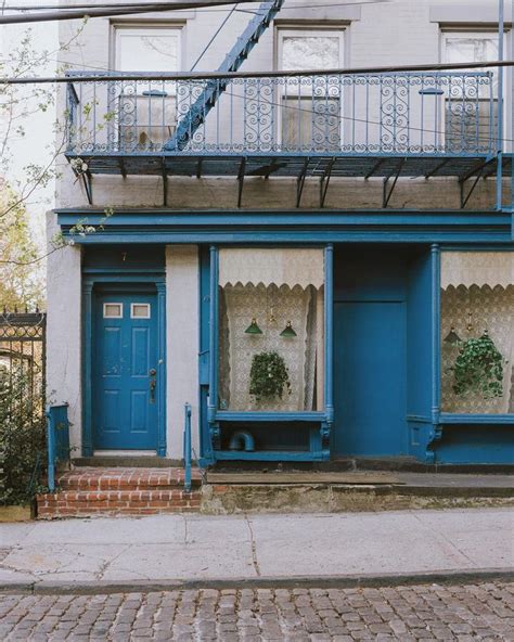 A Building With Blue Doors And Windows On The Side Walk In Front Of It