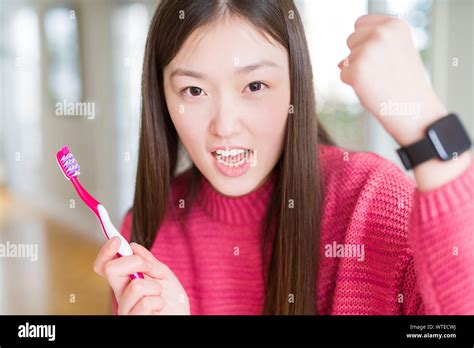 Beautiful Asian Woman Holding Toothbrush Annoyed And Frustrated