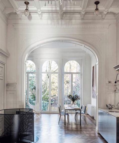 A Dining Room And Kitchen Area With Large Arched Doorways Leading To An