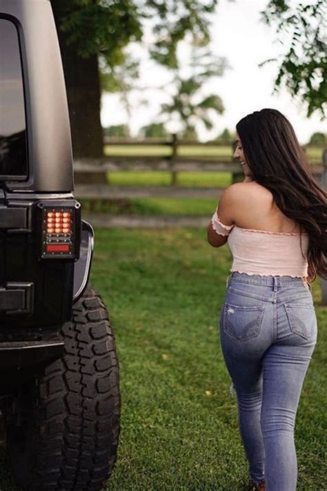 A Woman Walking Away From A Black Jeep