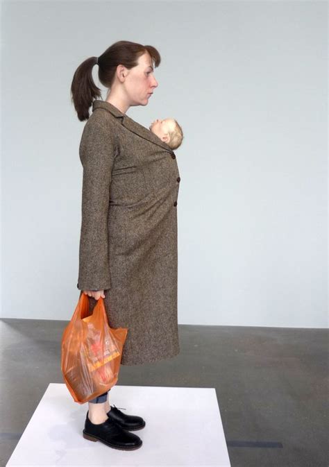 A Woman Holding A Baby In Her Arms While Standing On Top Of A White Sheet