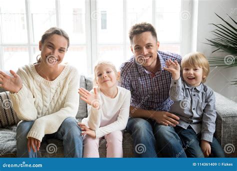 Familia Feliz Con Los Ni Os Que Agitan La Mano Que Mira La C Mara