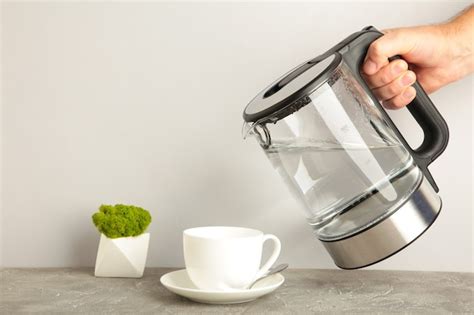 Premium Photo Kettle Pouring Boiling Water Into A Cup On Grey