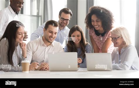 Happy Smiling Diverse Employees Using Laptop Watching Webinar Together