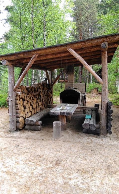 A Wooden Shelter With Logs Stacked Under It