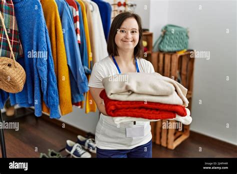 Brunette Woman With Down Syndrome Working As Shop Assistant Holding