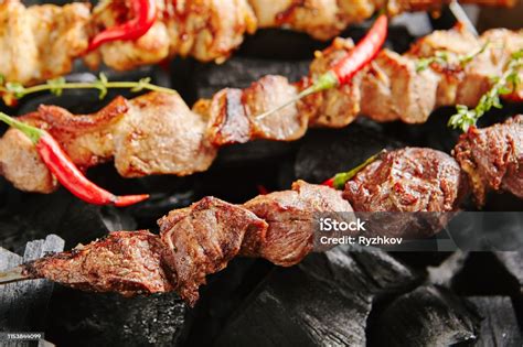 Hot Grilled Lamb Kebab Or Barbecue Shashlik On Charcoal Background With Herbs And Spices Closup