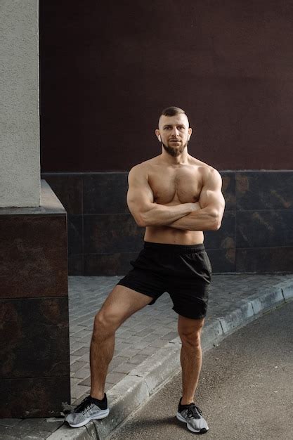 Hombre Musculoso Con El Torso Desnudo Usando Auriculares Posa Contra La