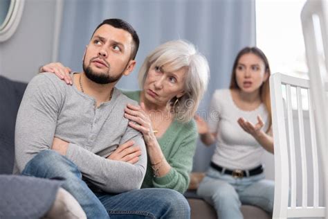 Old Woman Consoling His Adult Son During Conflict With His Wife Stock