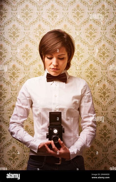 Photographer Focuses A Twin Lens Reflex Camera Peering Into Waist