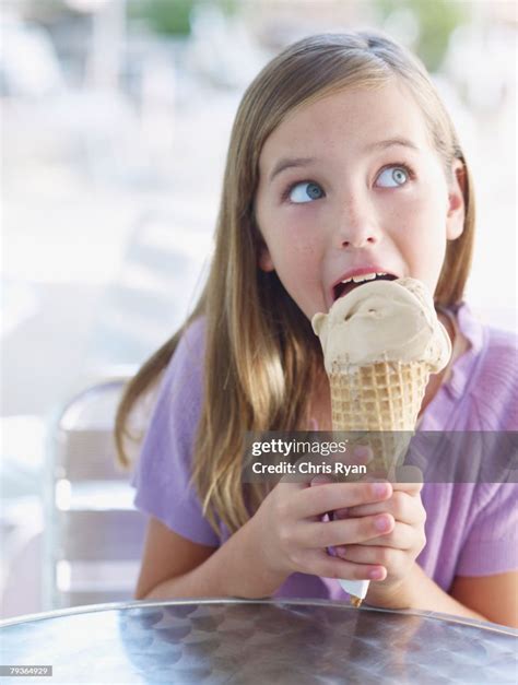 Young Girl On Outdoor Patio Licking Ice Cream Cone High Res Stock Photo