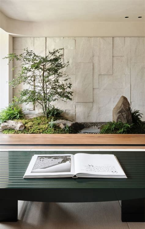 An Open Book Sitting On Top Of A Table Next To A Bonsai Tree And Rocks