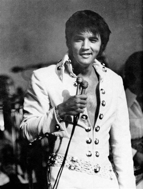 Elvis Presley Singing Into A Microphone While Holding A Mic In His