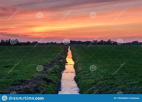 Typical Dutch Polder Landscape With Reflection Of A Multi Coloured