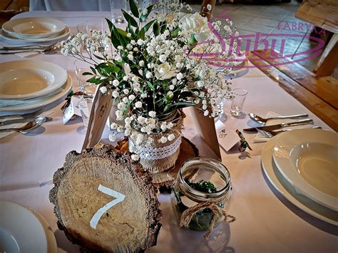 The Table Is Set With White Flowers And Silverware