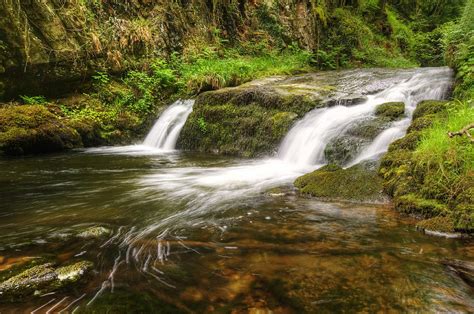 Stunning Waterfall Flowing Over Rocks Through Lush Green Forest