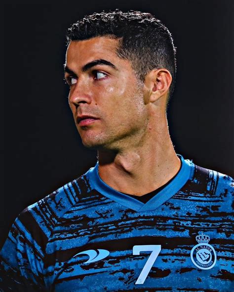 A Soccer Player In Blue And Black Jersey Looking At The Camera With Serious Look On His Face