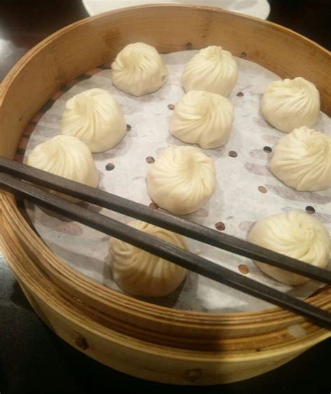 Some Dumplings And Chopsticks In A Wooden Bowl